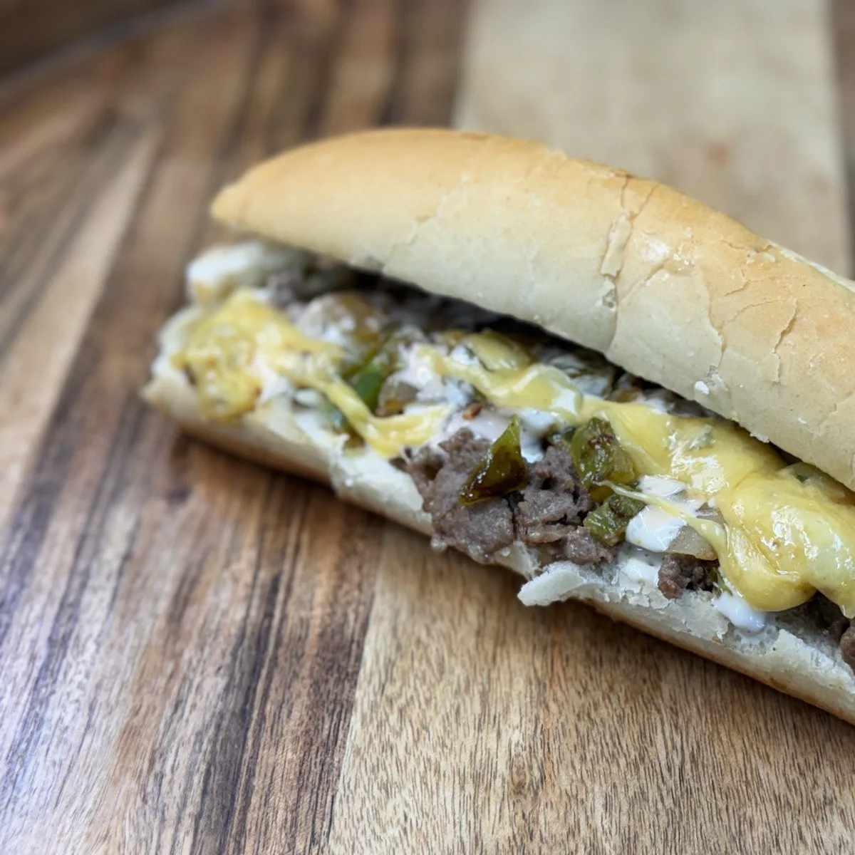 Philly Cheesesteak Sandwich with halal beef, melted cheese, onions and peppers on soft roll