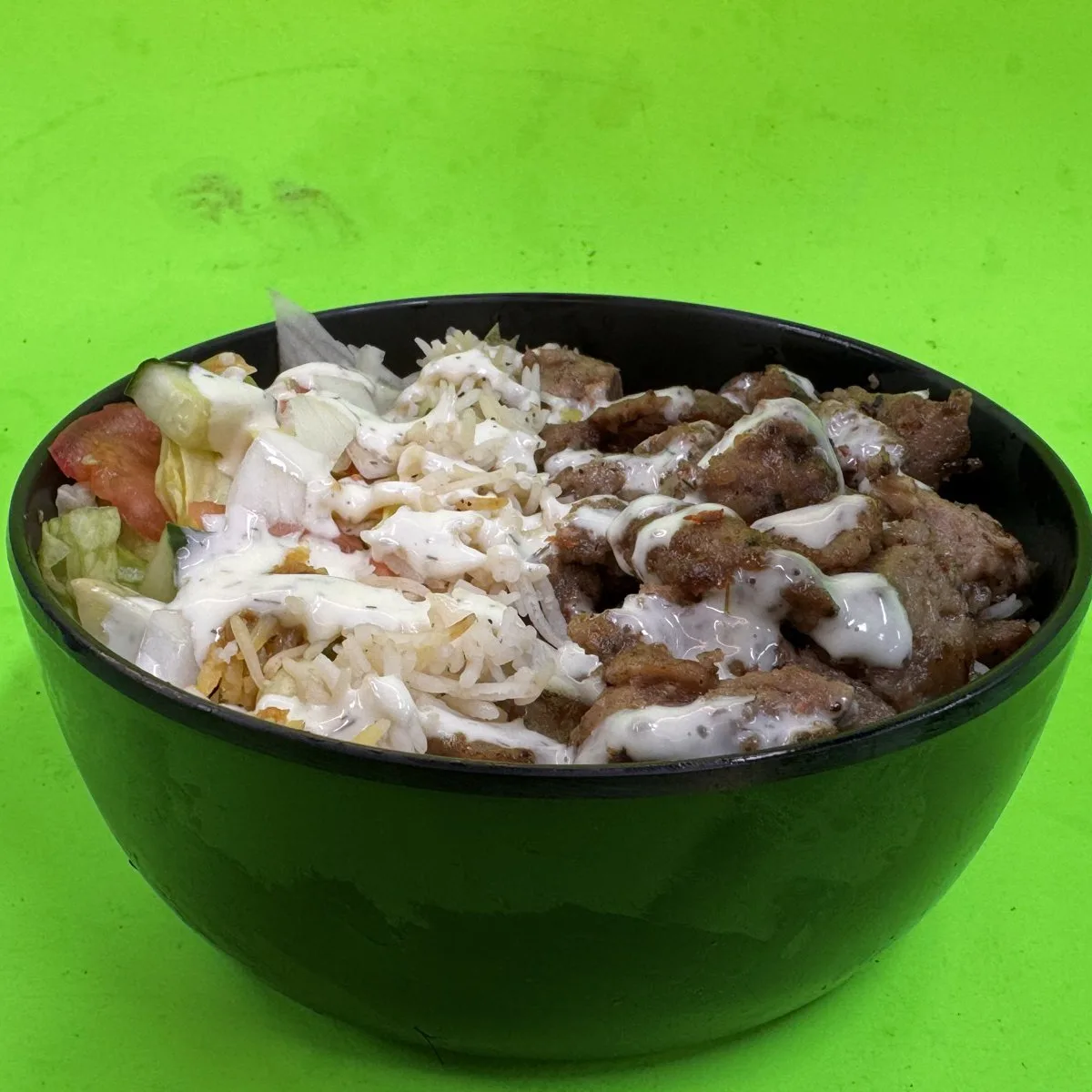 Lamb Over Rice platter with tender halal lamb pieces, white rice, fresh vegetables and sauce