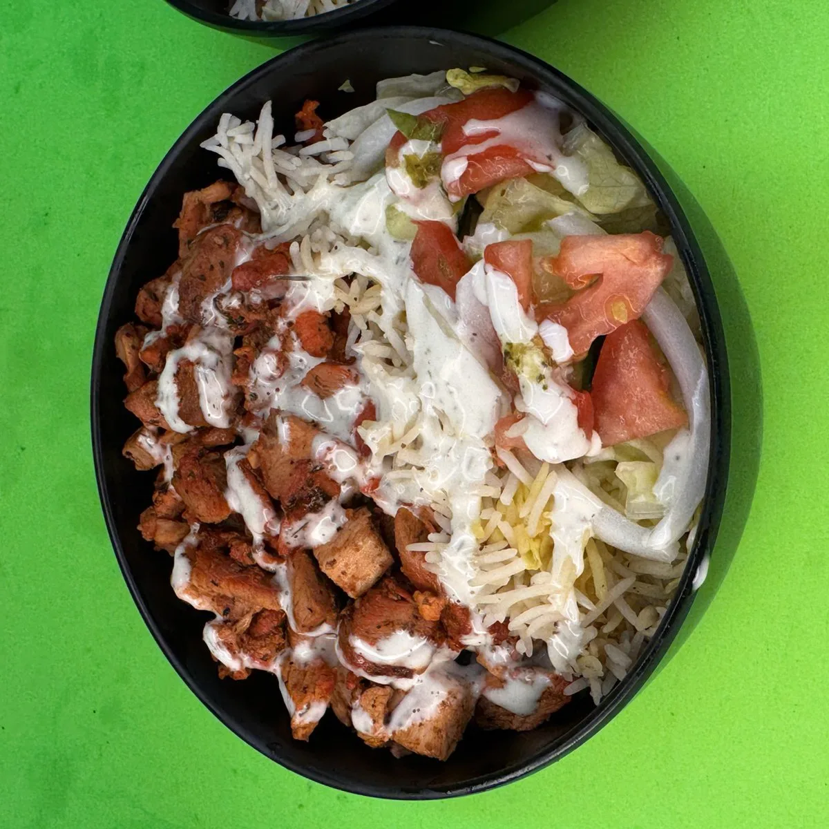 Chicken Over Rice platter with grilled halal chicken, white rice, tomato and lettuce, cooked fresh to order