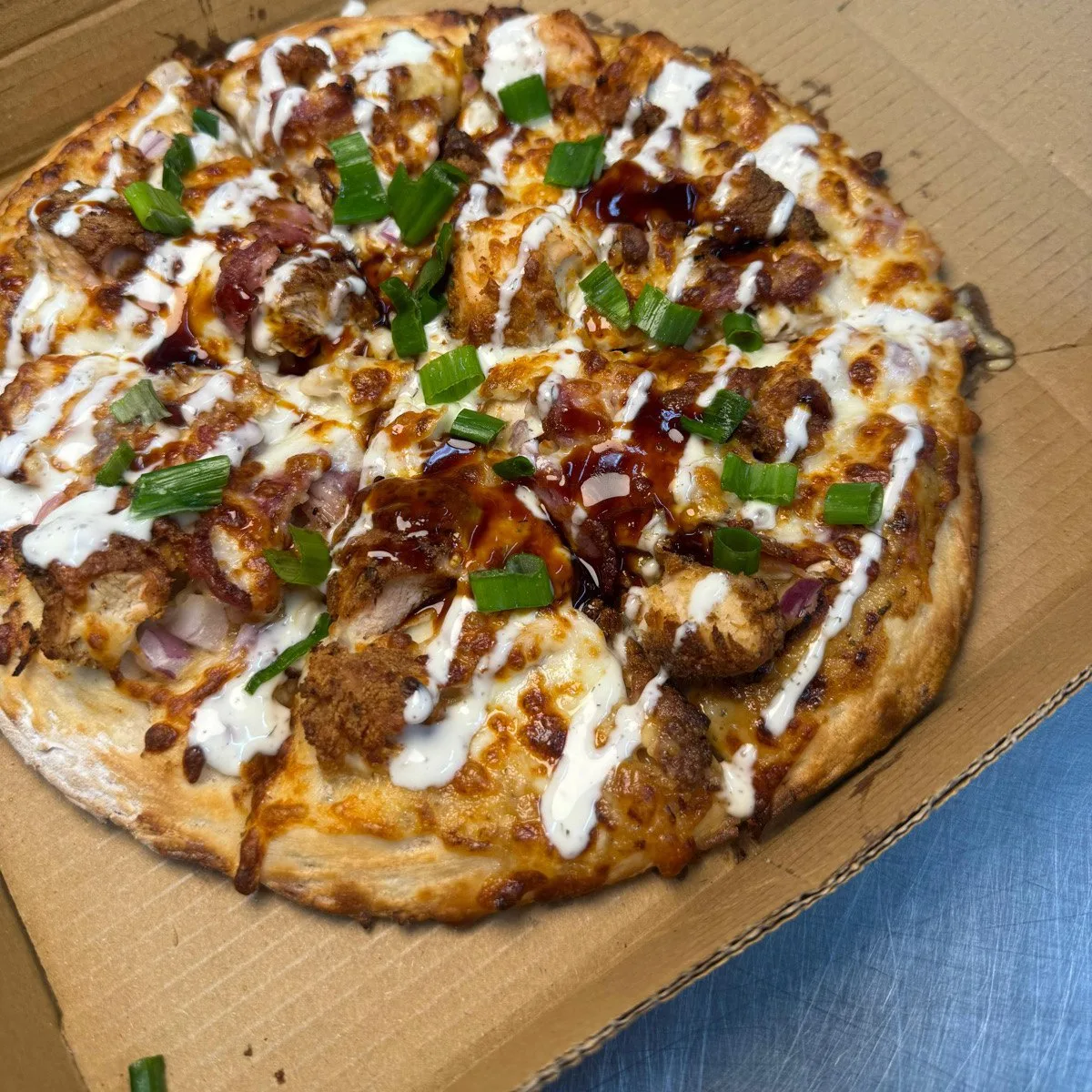 Korean BBQ Chicken Pizza with spiced chicken, BBQ sauce, green onions and white drizzle, halal takeaway